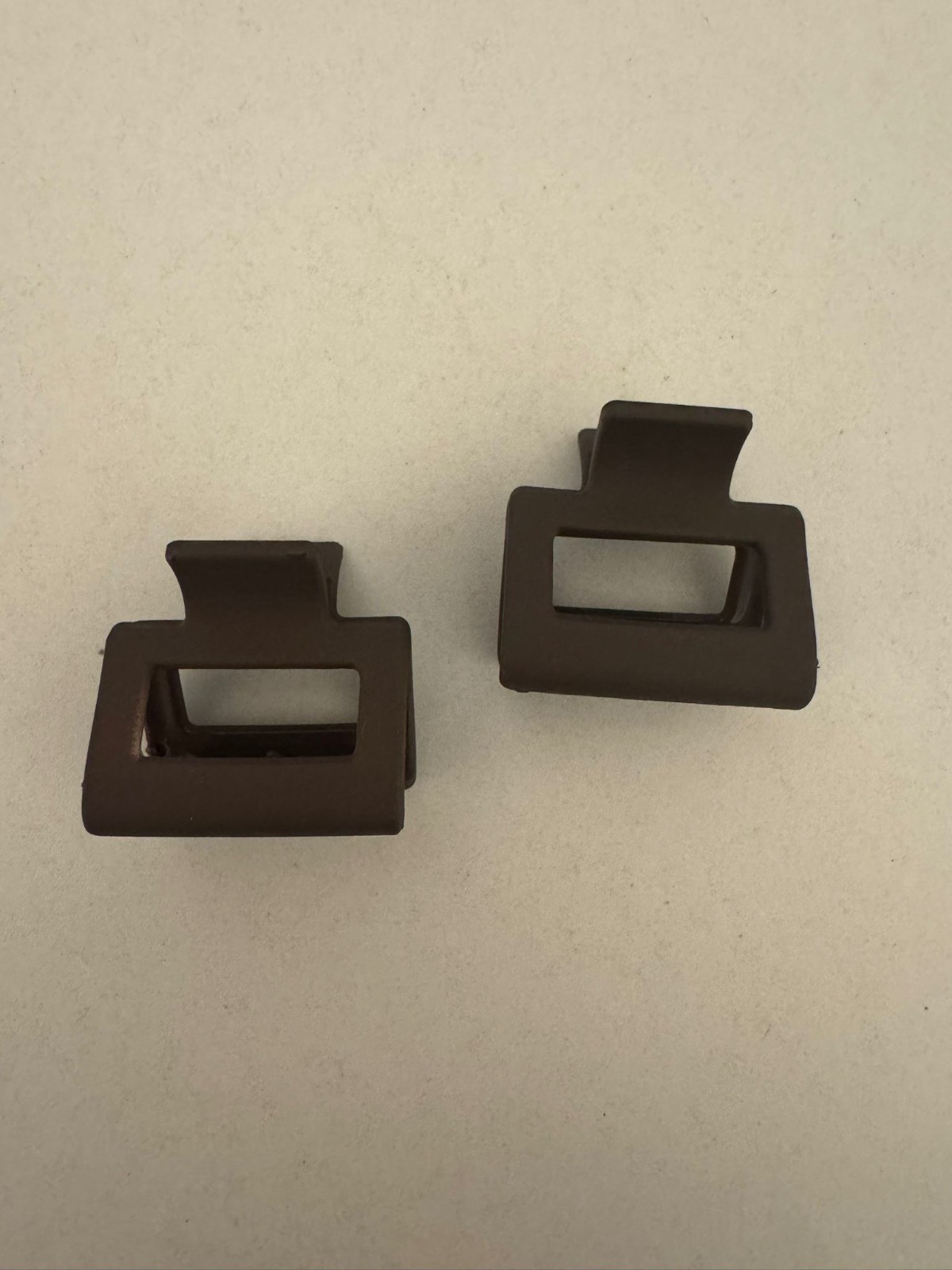 Two beautiful, matte brown plastic hair clips, perfect for styling.
