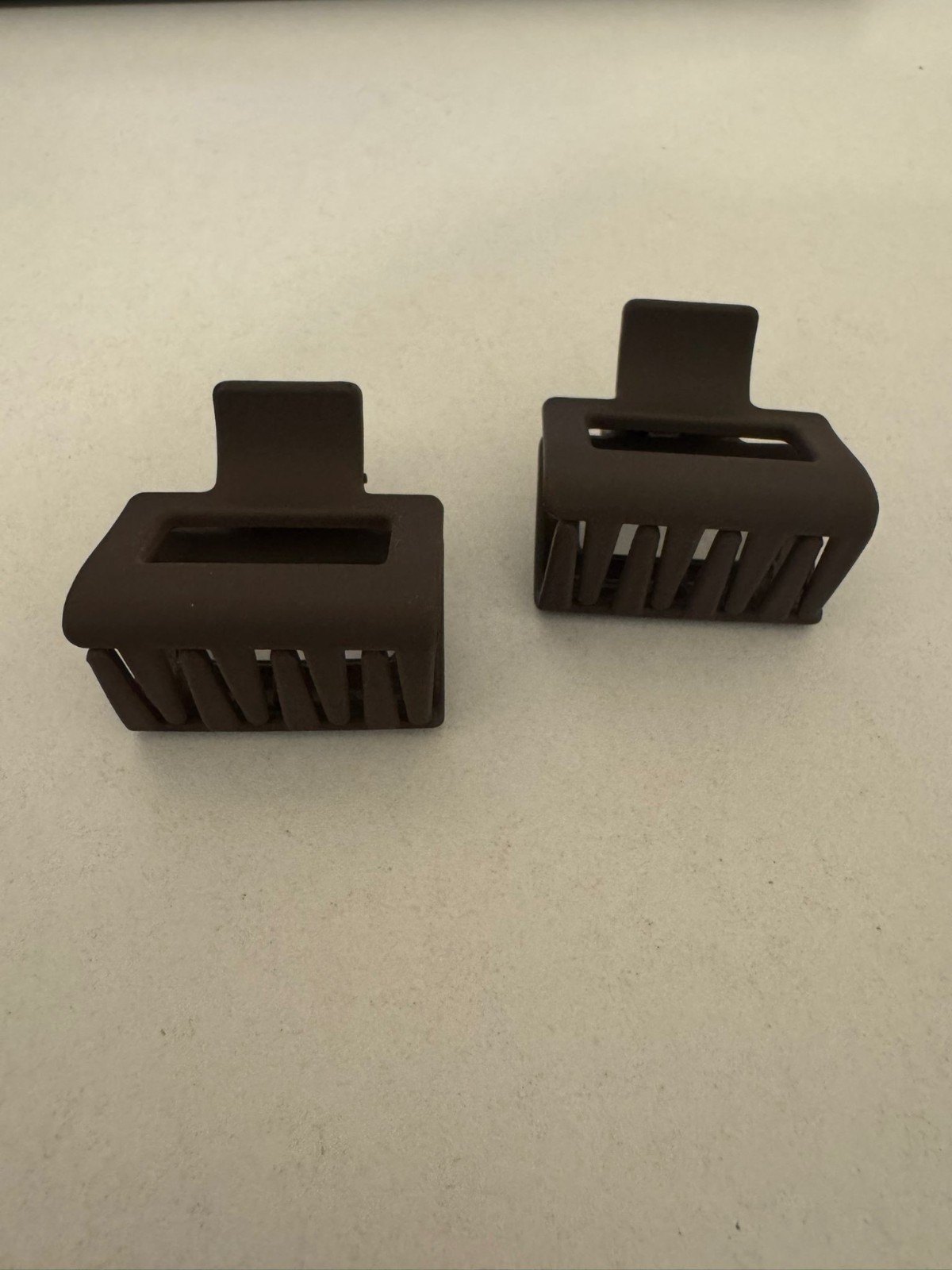 Two beautiful, matte brown plastic hair clips, perfect for styling.