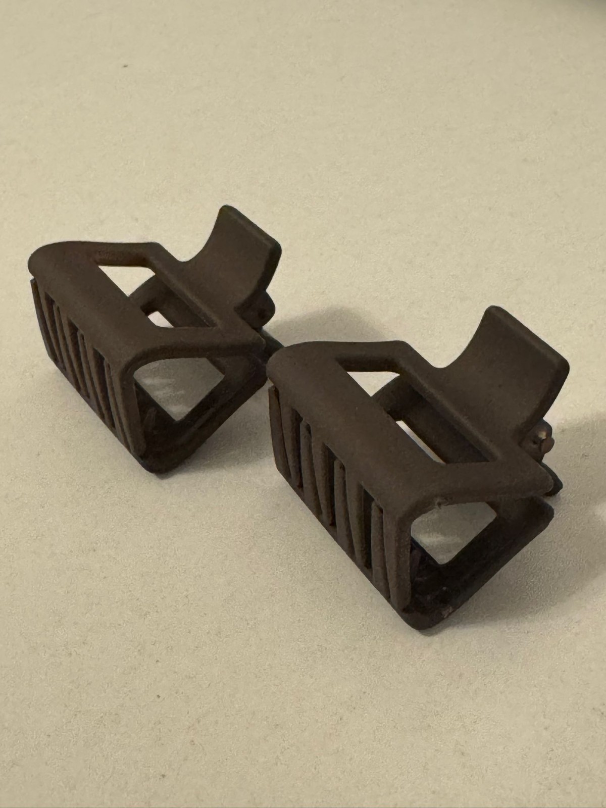 Two beautiful, matte brown plastic hair clips, perfect for styling.