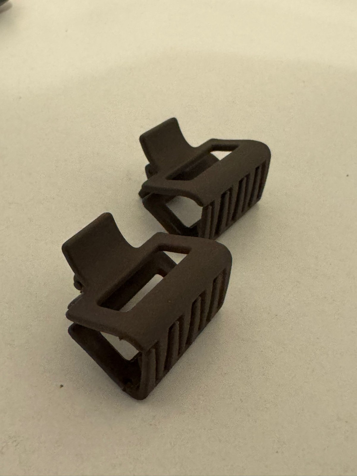 Two beautiful, matte brown plastic hair clips, perfect for styling.